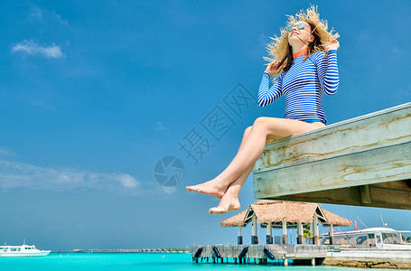 女人坐木制海滩码头上马尔代夫的暑假高清图片