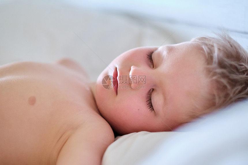三岁的蹒跚学步的男孩睡枕头上图片