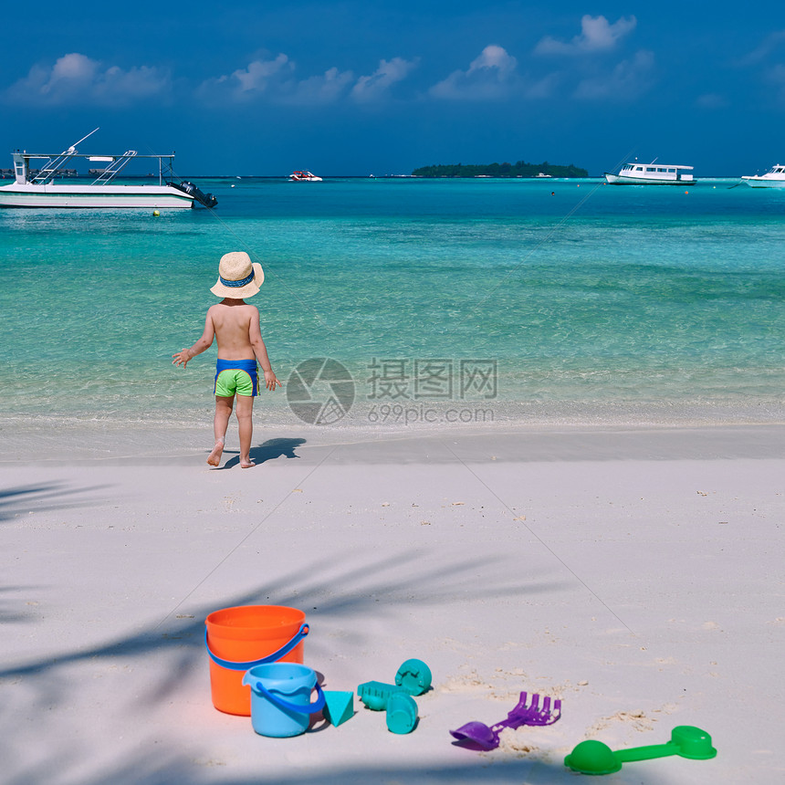 三岁的蹒跚学步的男孩海滩上玩海滩玩具马尔代夫的暑假家庭假期图片