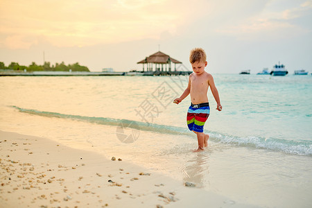 三岁的蹒跚学步的男孩海滩上日落马尔代夫的暑假家庭假期图片