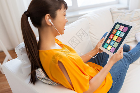 自动化,物联网人的快乐的轻亚洲妇女坐沙发上的耳机与智能家居图标平板电脑屏幕上平板电脑屏幕上智能家居图标的亚背景图片