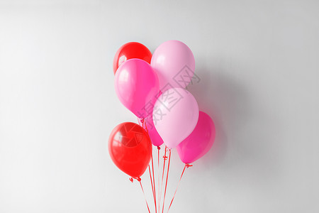 情人节生日派装饰堆粉红色红色的气球白色的墙上生日派的粉红色红色气球图片