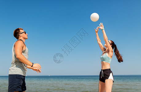 玩排球健身,运动生活方式的快乐的夫妇与球打排球夏季海滩快乐的夫妇夏天的海滩上打排球背景