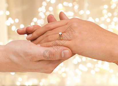珠宝,建议豪华夫妇的手与订婚戒指节日灯背景用订婚戒指合上两只手图片
