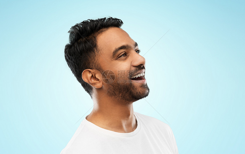 情感,表达人的轻的笑印度男子蓝色背景灰色背景上轻的笑着的印度男人图片