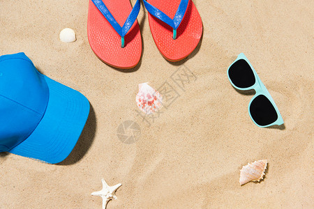 假期暑假的帽子,拖鞋,太阳镜贝壳海滩沙滩上帽子,阴影贝壳海滩沙子图片
