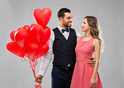 情人节,爱人的幸福的夫妇与红色心形气球灰色背景幸福的红色心形气球图片