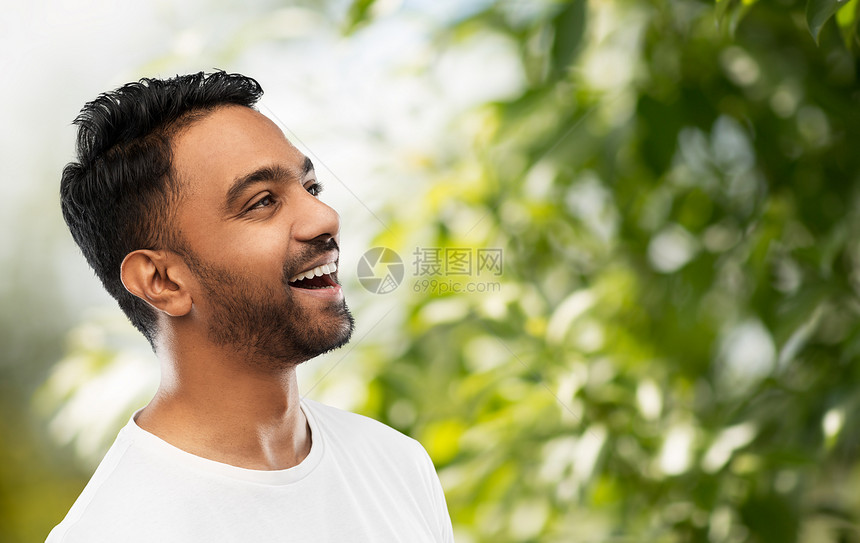 情感,表达人的轻的笑印度男子绿色自然背景轻的笑着的印度男子自然背景图片