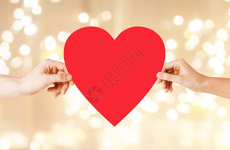 健康,爱关系的特写夫妇的手与大红心节日的灯光背景双手捧着红心背景图片