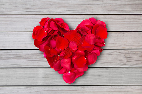 爱情,浪漫,情人节假期的红色玫瑰花瓣的心形特写红色玫瑰花瓣的心形背景图片