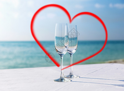 情人节,暑假爱情两个香槟杯框红色心形海上两个红色心形香槟杯背景图片
