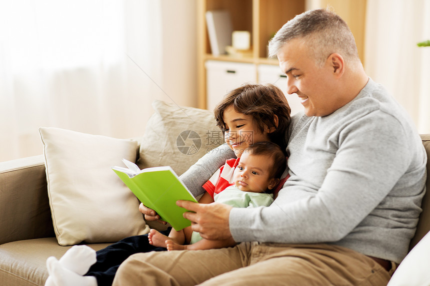 家庭,父亲人的快乐的父亲与青春期前小儿子家阅读书籍快乐的父亲儿子家看书图片