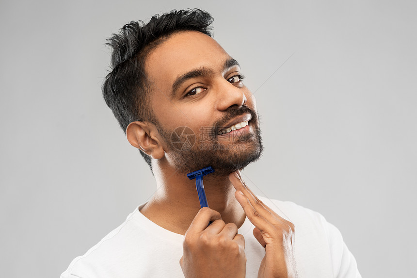 美容人的微笑的印度男子剃须胡须与手动剃须刀刀片灰色背景印度男人用剃须刀刮胡子图片