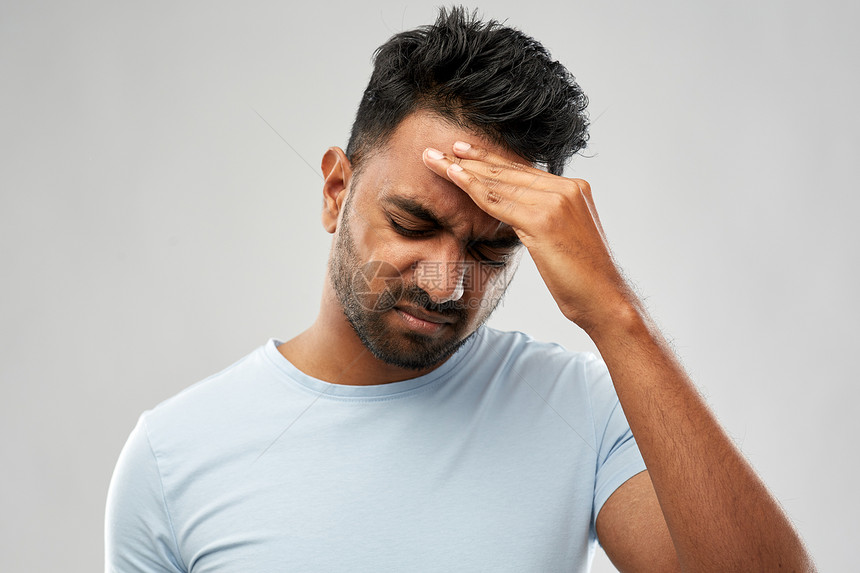 人,健康问题压力幸的印度男人灰色背景下头痛幸的印度男人头痛图片