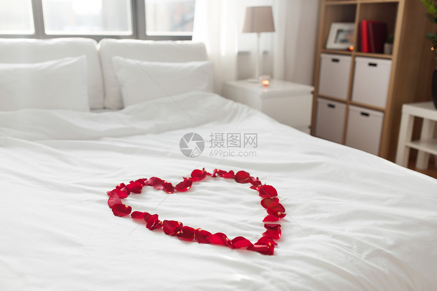 情人节,浪漫的约会假期床装饰的心由红色花瓣卧室家里舒适的卧室装饰情人节图片