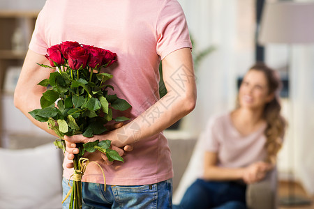 夫妻,关系人的快乐的女人看着男人背后藏着玫瑰女人男人背着玫瑰图片