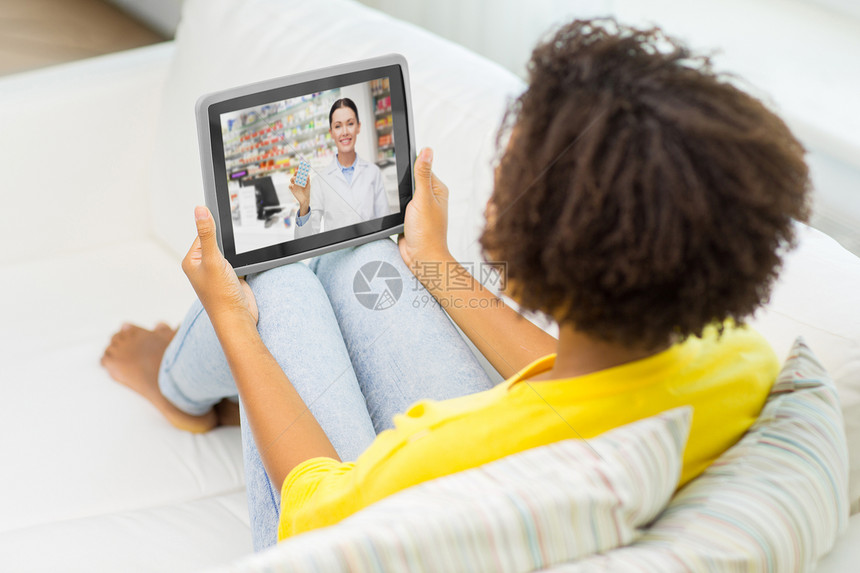 医学,技术医疗保健非裔美国轻妇女与药剂师视频聊天平板电脑电脑家里女人平板电脑上与药剂师进行视频聊天图片