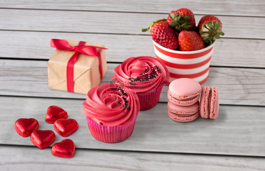 情人节糖果糖霜纸杯蛋糕,红色心形巧克力糖果,马卡龙,草莓礼品盒情人节的红色糖果图片