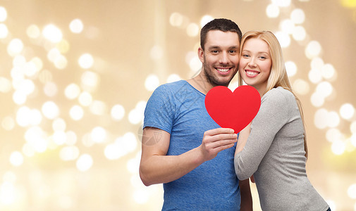 爱,情人节慈善幸福的夫妇大红心米色背景节日灯幸福的,红色的心节日的灯光下图片