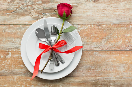 情人节浪漫的晚餐红玫瑰花套盘子餐具木制桌子上红玫瑰套盘子上,桌子上餐具图片