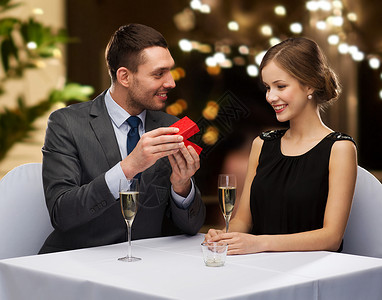 葡萄酒盒子样机求婚,情人节人们的快乐的男人展示女人餐厅的红色盒子节日灯的背景男人餐厅用红色盒子展示女人背景
