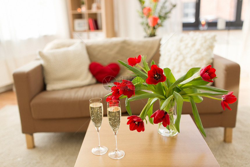 情人节,浪漫的约会假期两个香槟杯红色郁金香花客厅家里的桌子上情人节的香槟杯鲜花图片