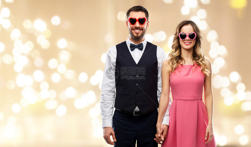 情人节,爱人的幸福的夫妇心形太阳镜节日的灯光背景戴着心形太阳镜的幸福夫妇图片
