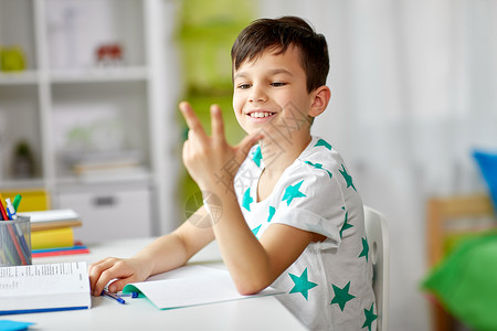 教育,童学校的快乐的学生男孩家里用手指数数男孩作业,用手指数数背景图片