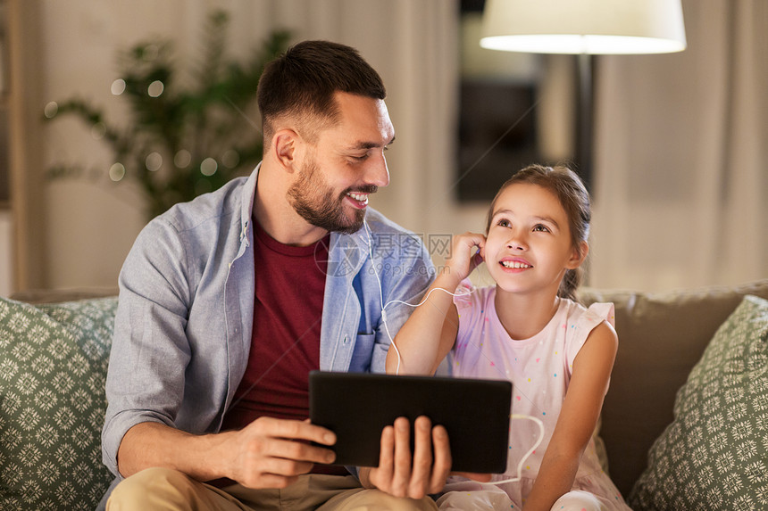 家庭,父亲技术快乐的父亲小女儿与平板电脑耳机家里听音乐父亲女儿平板电脑上听音乐图片
