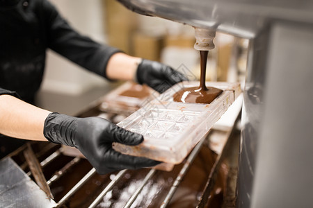 生产,烹饪人们的糖果填充糖果模具与巧克力糖果店糖果师糖果店巧克力糖果图片