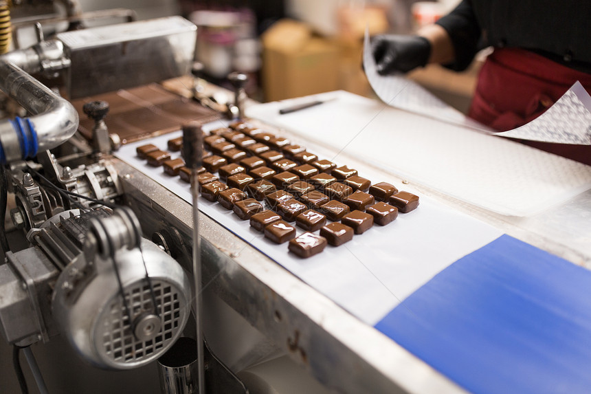 糖果生产行业巧克力糖果加工输送机糖果店糖果传送带上的巧克力糖果图片