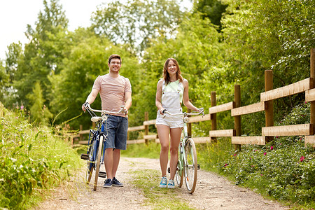 人们,休闲生活方式的快乐的轻夫妇与自行车夏季公园夏天公园里自行车的快乐夫妇背景图片
