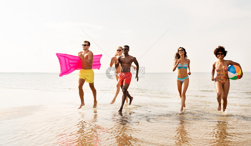 友谊,暑假游泳快乐的朋友与浮动床垫充气球海滩上跑步朋友们用沙滩球游泳床垫跑步图片