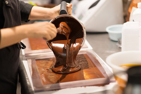 生产,烹饪人的糖果填充模具与巧克力糖果店糖果师糖果店巧克力甜点背景图片