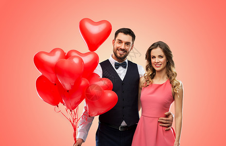 情人节,爱人的幸福的夫妇与红色心形气球生活的珊瑚背景幸福的红色心形气球图片