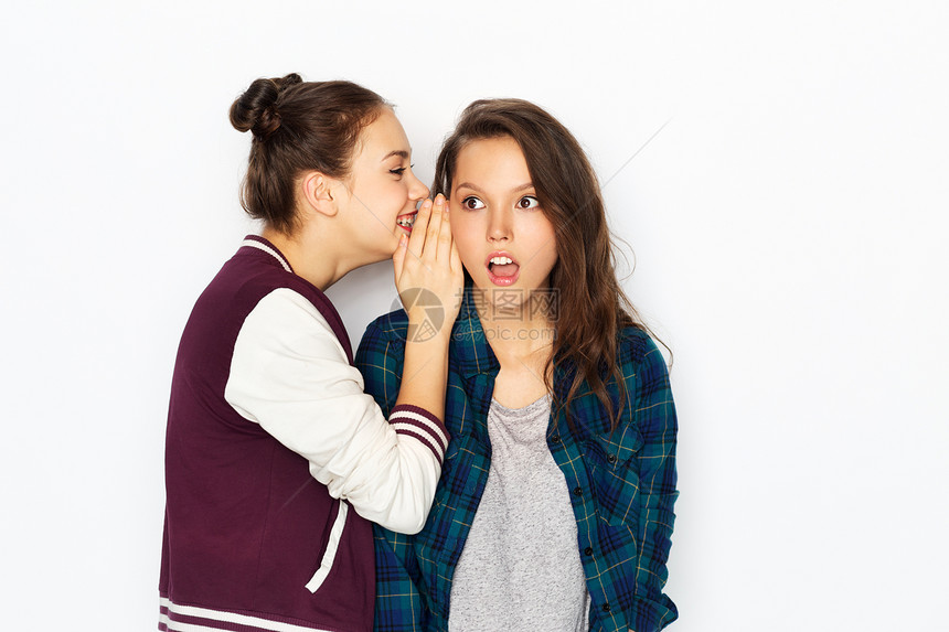友谊沟通人的快乐的十几岁女孩白色背景下闲聊分享秘密十几岁的女孩闲聊分享秘密图片