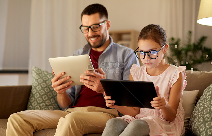 家庭,父亲技术快乐的父亲女儿戴着眼镜,晚上家用平板电脑父亲女儿家用平板电脑图片