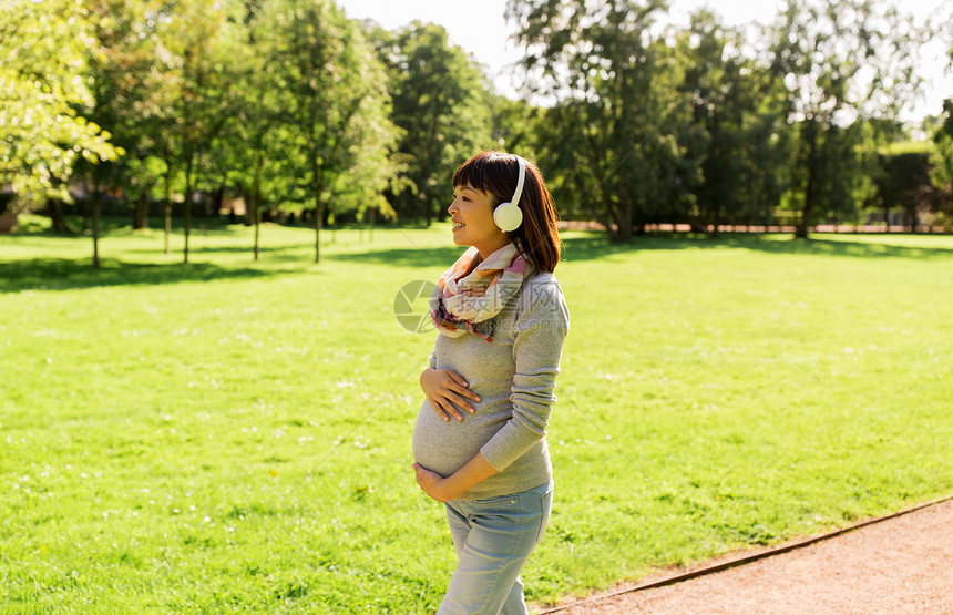 怀孕,人技术快乐的怀孕亚洲妇女戴着耳机公园散步听音乐快乐怀孕的亚洲女人戴着耳机公园图片