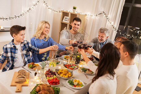 庆祝,节日人们的快乐的家庭吃晚餐聚会,喝红酒家品尝幸福的家庭家里举行晚宴背景图片