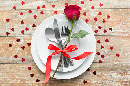 情人节,餐桌浪漫的晚餐红玫瑰花套盘子与餐具木制背景把红玫瑰花关盘子上图片