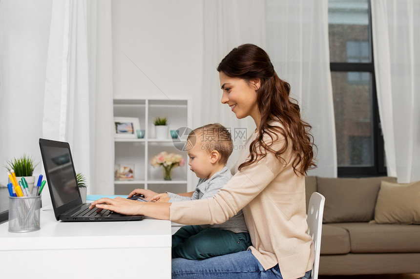 母亲,多任务,家庭人的快乐的母亲与婴儿笔记本电脑家里工作快乐的母亲带着孩子笔记本电脑家工作图片
