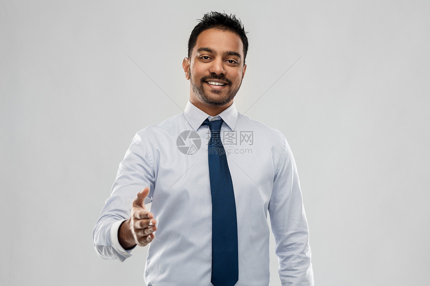 商业,上族人的微笑的印度商人伸出手灰色背景上握手印度商人伸出手握手图片