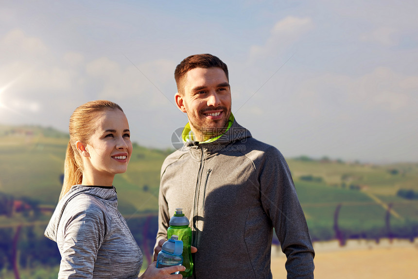 健身,运动人的微笑夫妇与瓶装水乡村景观背景户外运动后,带着瓶子的水图片
