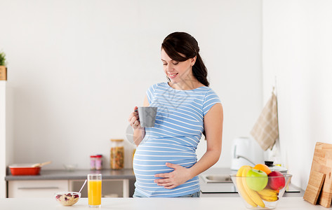 孕妇早餐怀孕,人们健康的饮食观念快乐的孕妇喝杯茶食物,家里的厨房吃早餐快乐的孕妇家里的厨房里着杯子背景
