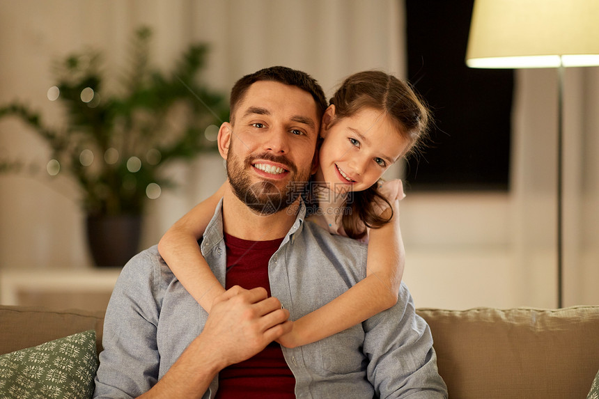 家庭,父爱,休闲人的快乐微笑的父亲小女儿拥抱家里晚上快乐的爸爸小女儿家里拥抱图片