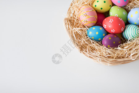 篮子彩蛋复活节,假日,传统象彩色鸡蛋柳条篮子白色背景篮子里彩色复活节彩蛋背景
