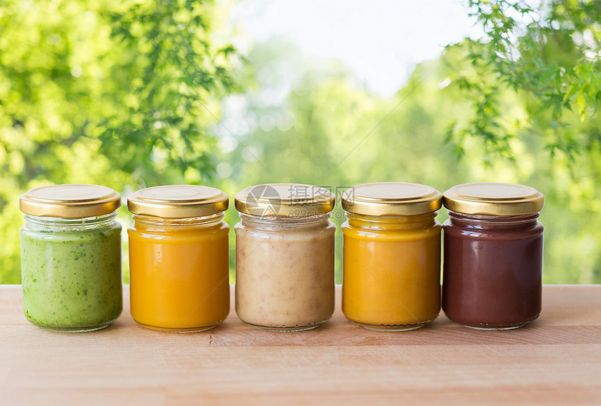 健康饮食,婴儿食品营养蔬菜水果泥璃瓶木制桌子上绿色自然背景罐子里的蔬菜水果泥婴儿食品图片