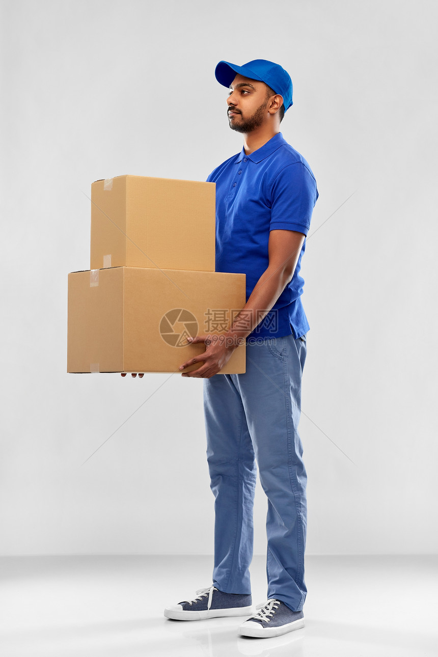 邮件服务装运印度送货人员与包裹箱蓝色制服灰色背景印度送货人,包裹箱蓝色的图片