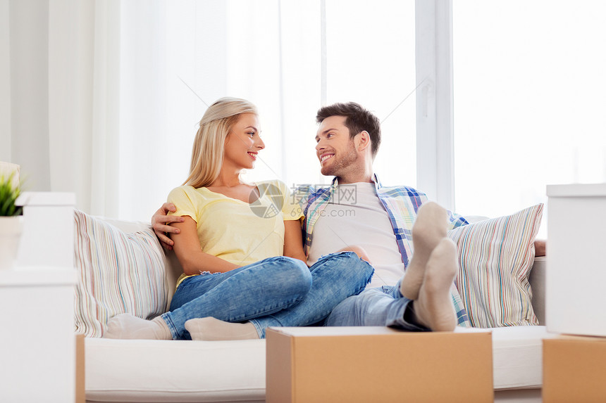 抵押贷款,移动房地产幸福的夫妇与盒子休息沙发上的新家幸福的夫妇带着箱子搬新家图片