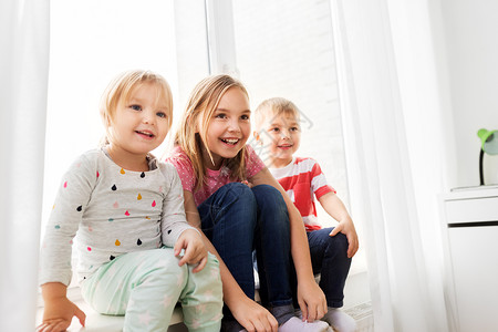 童,休闲家庭观念快乐的孩子坐窗台上快乐的小孩子坐窗台上图片